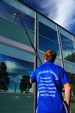 Window cleaner using a water fed pole system to clean glass on a commercial building